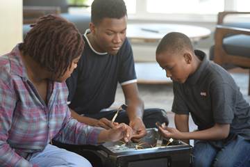 Three people taking apart a computer.