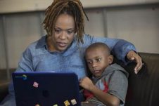 A parent teaching her child something on the laptop.