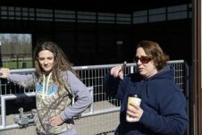 Two women in front of a gate.