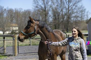 A woman walking a horse.