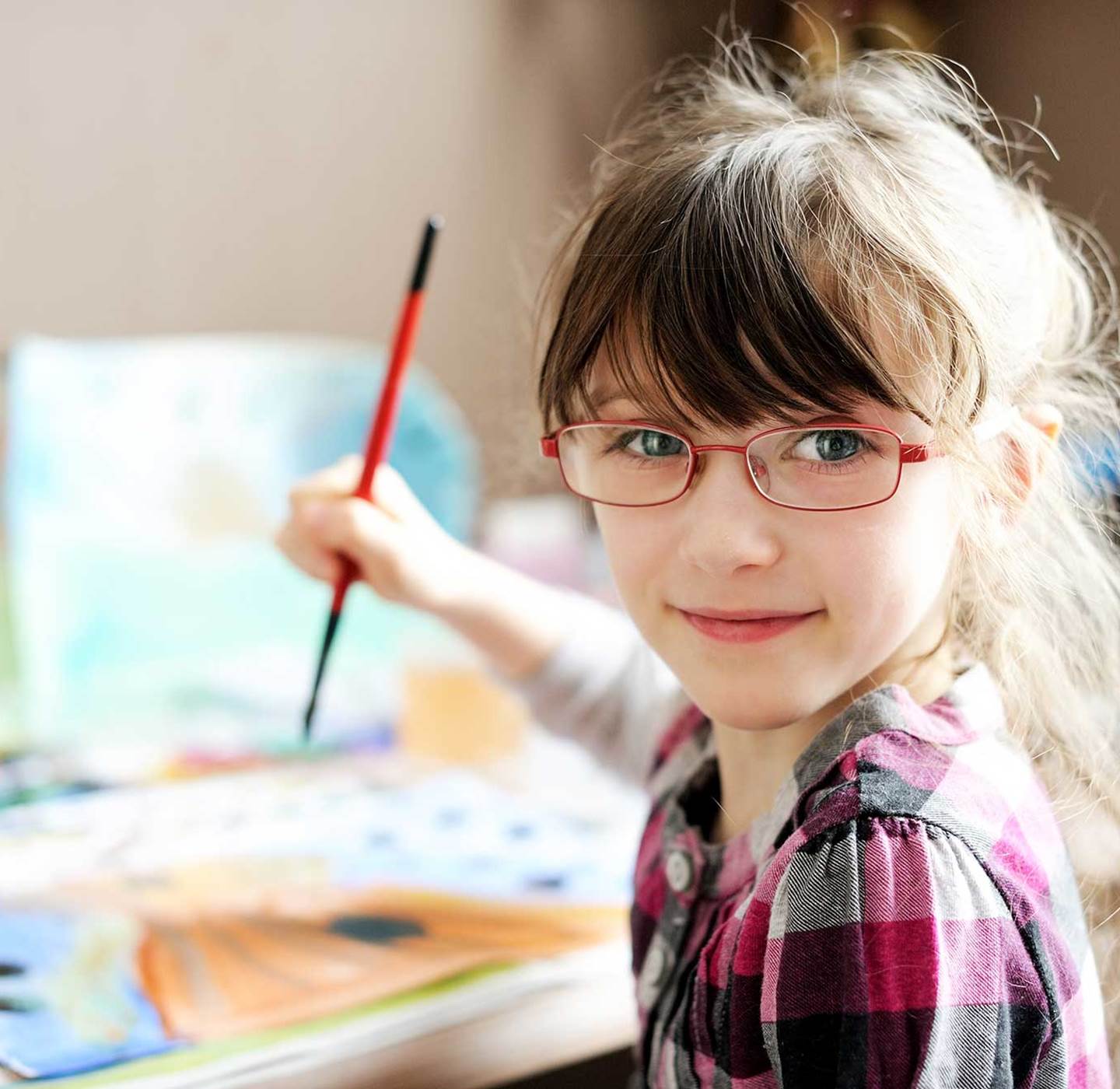 A young girl painting.