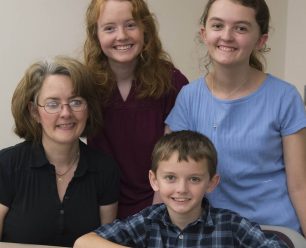 A family of four smiling.