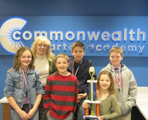 The chess team comprised of five children and the coach holding their trophy.