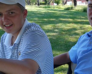 Two people in a golf cart.