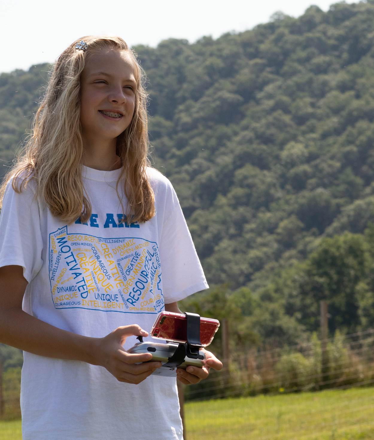 A girl with a remote, flying a drone.