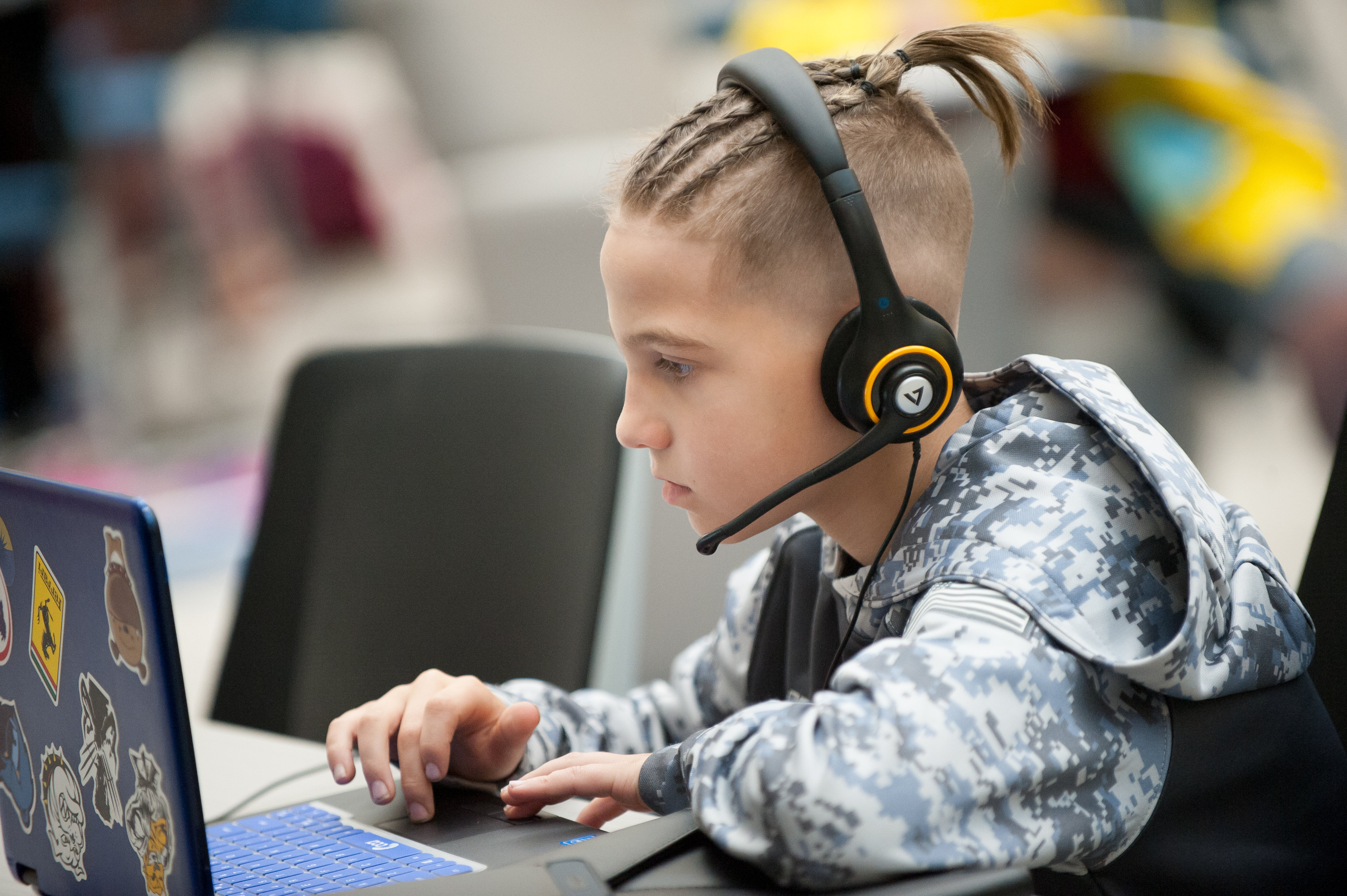 Boy wearing a headset and working on his laptop