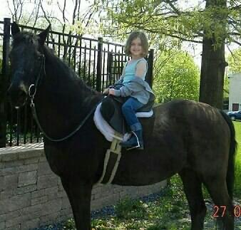 Bella riding her horse as a young girl
