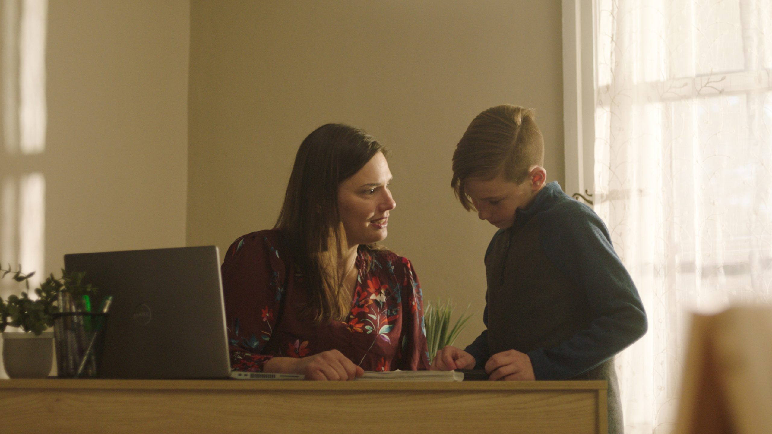 mother talking to child next to computer