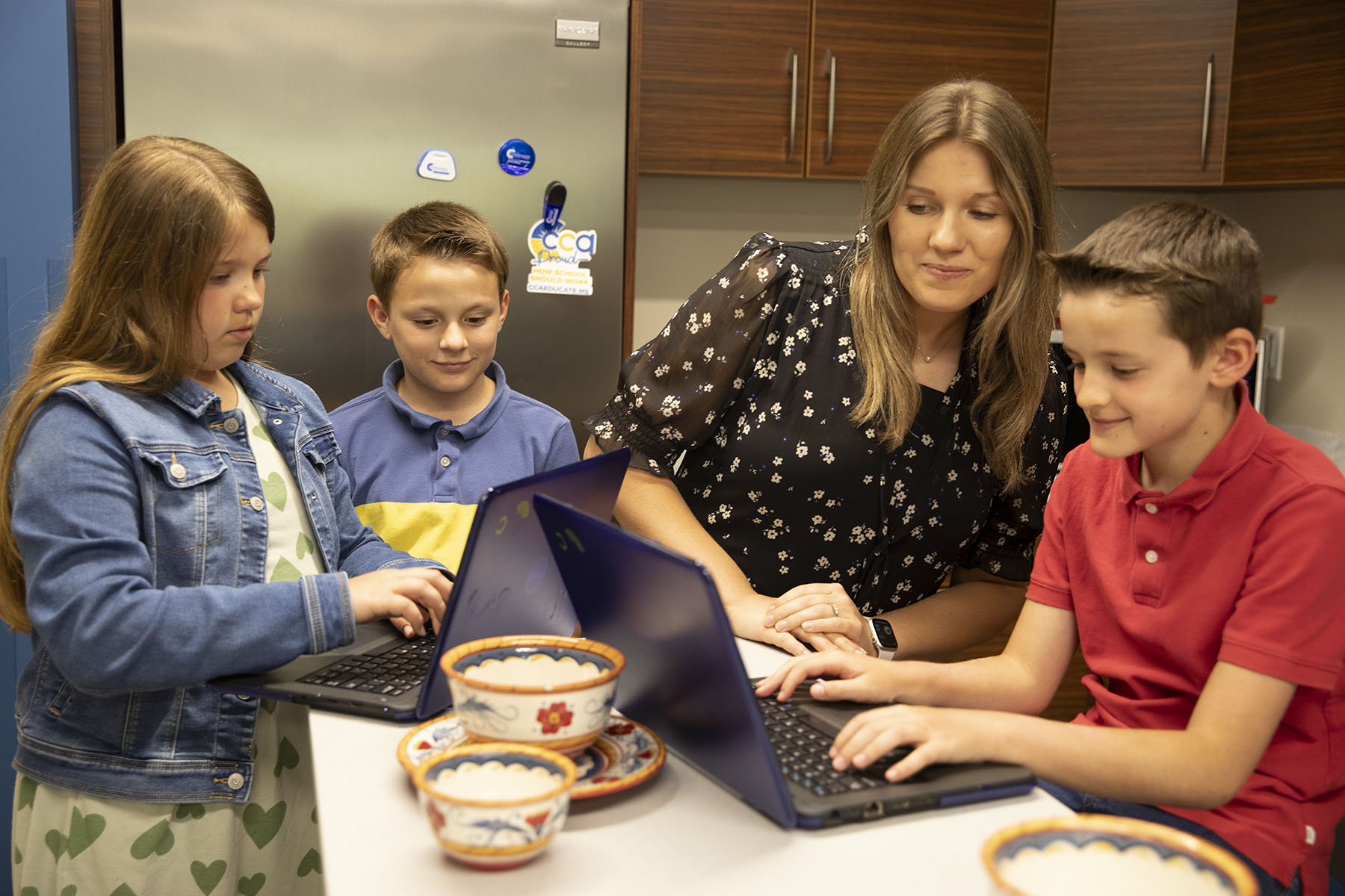 Family looking at computers on kitchen table