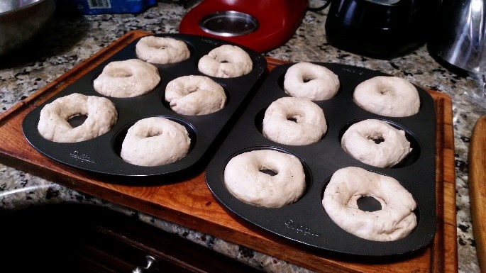 Pre-made bagels sitting on baking sheets