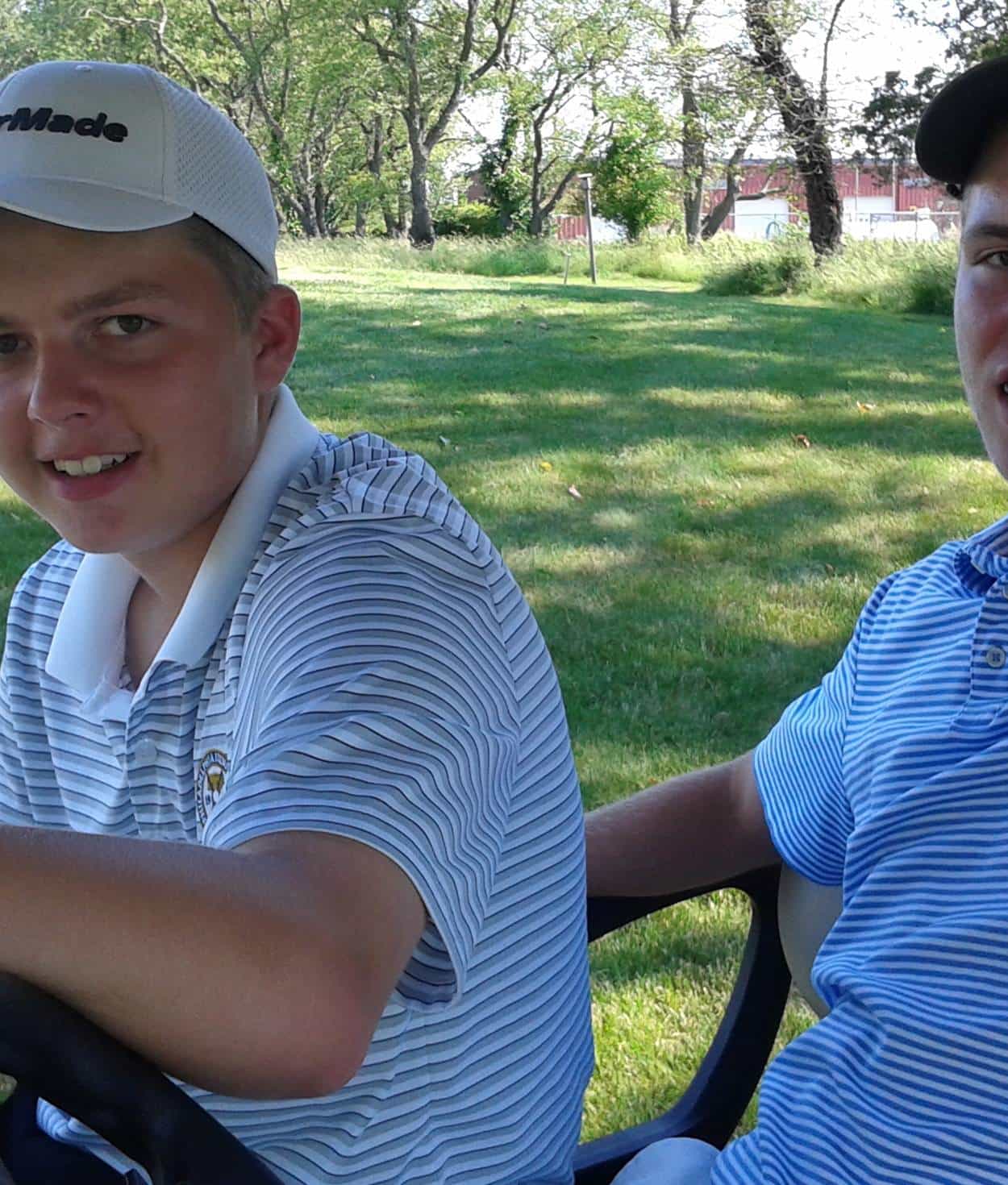 Two people in a golf cart.