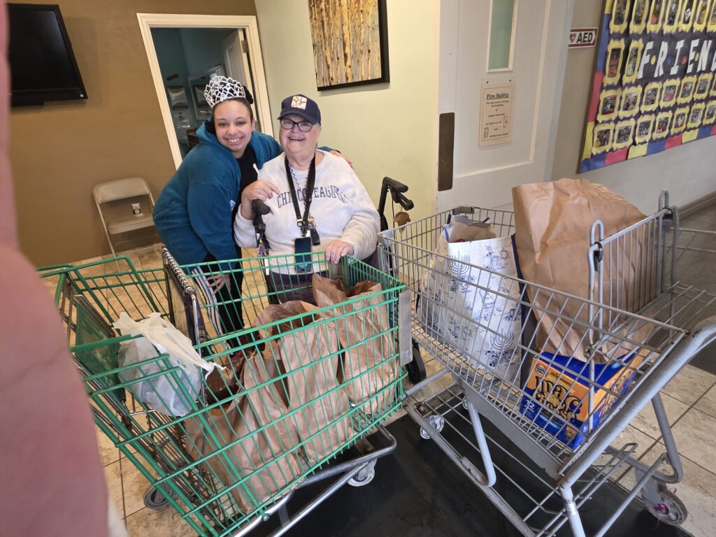 Jaylene delivers two shopping carts of food from her food drives to help the community.